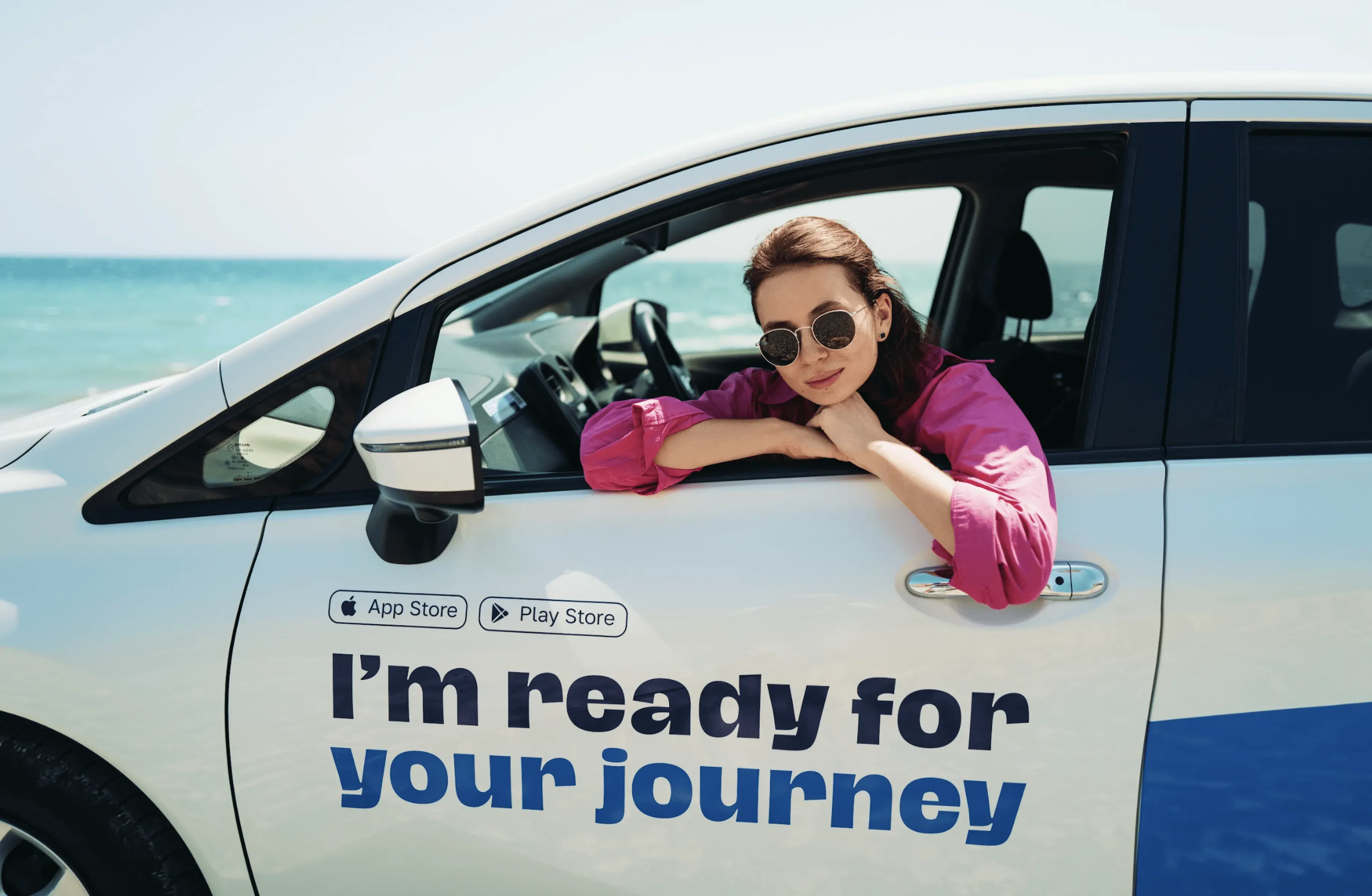 A woman leans out of a RideNow car by the beach, showcasing CT Mobility's role in expanding their fleet to 500+ cars and enhancing rental management